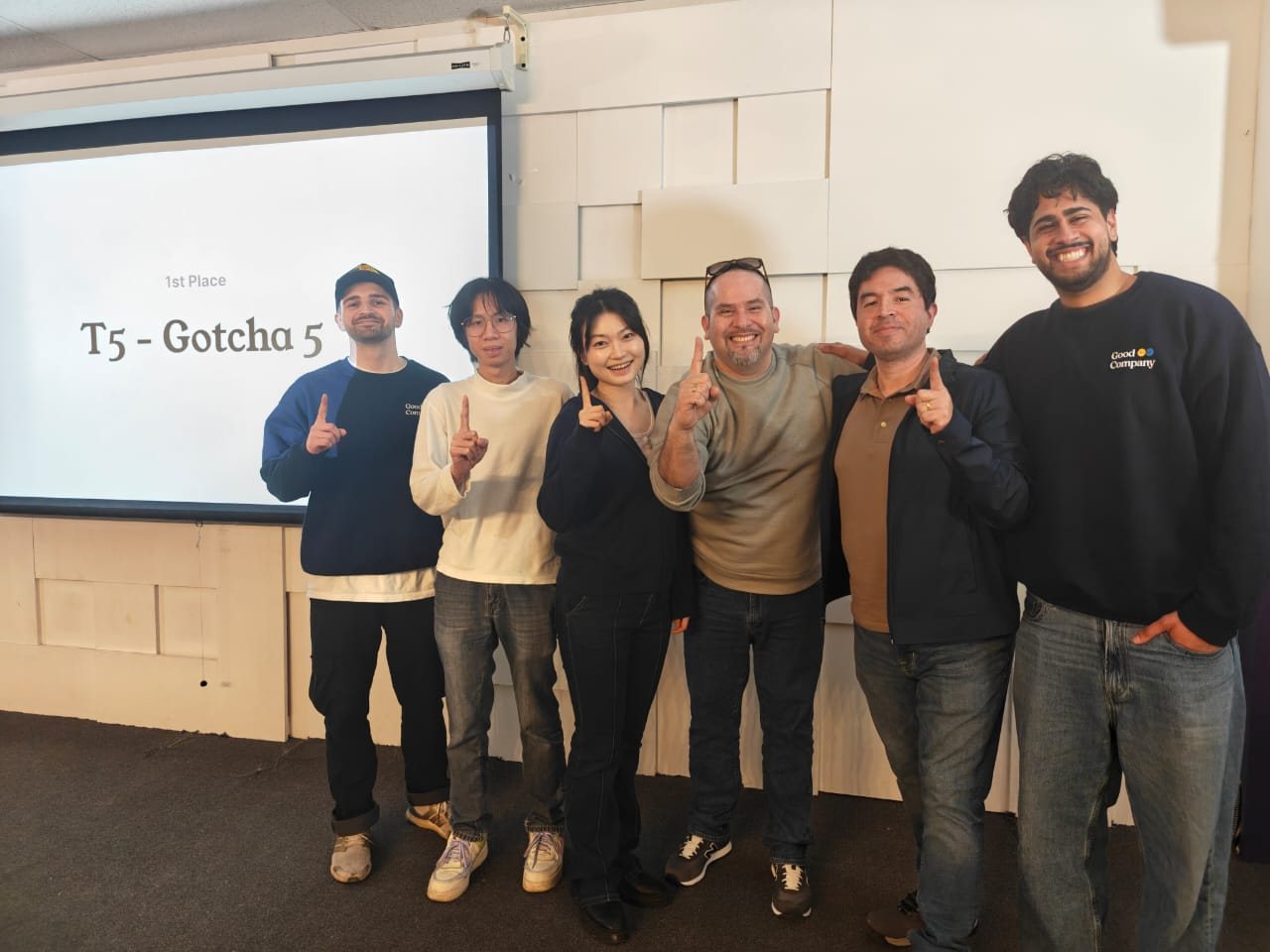 Team Gotcha 5 and the judges, each holding up one finger, in front of the 1st Place slide