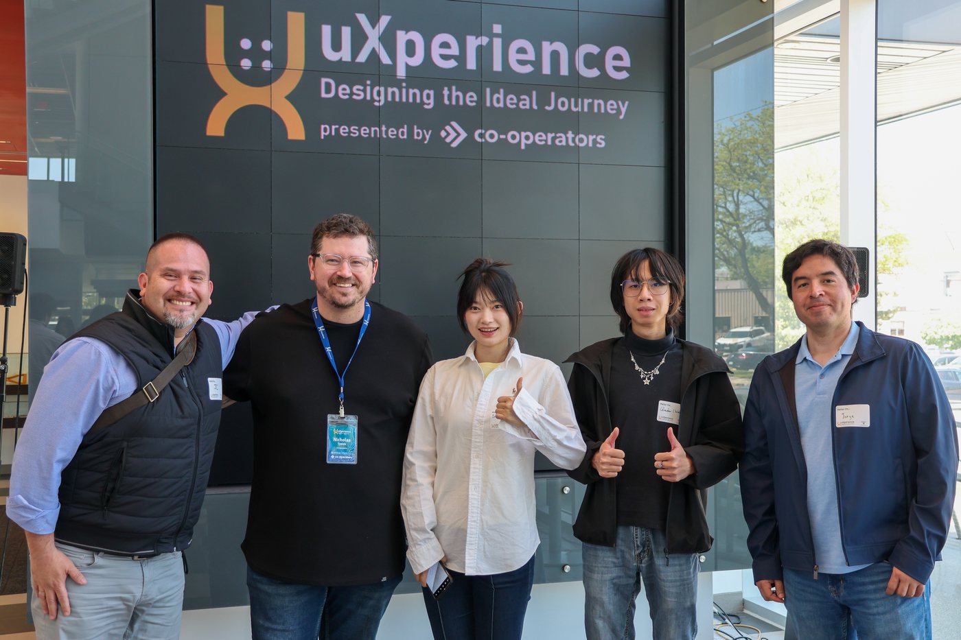 Serena with her team and hosts in front of the uXperience banner